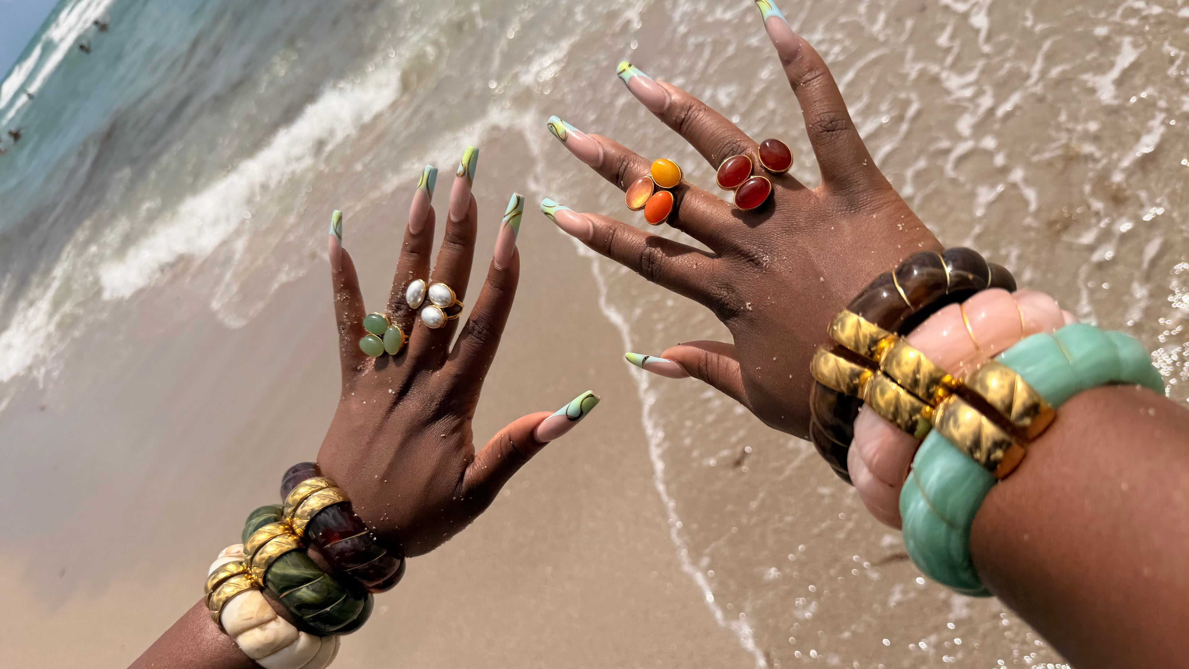 Close-up of hands with jewelry on a beach