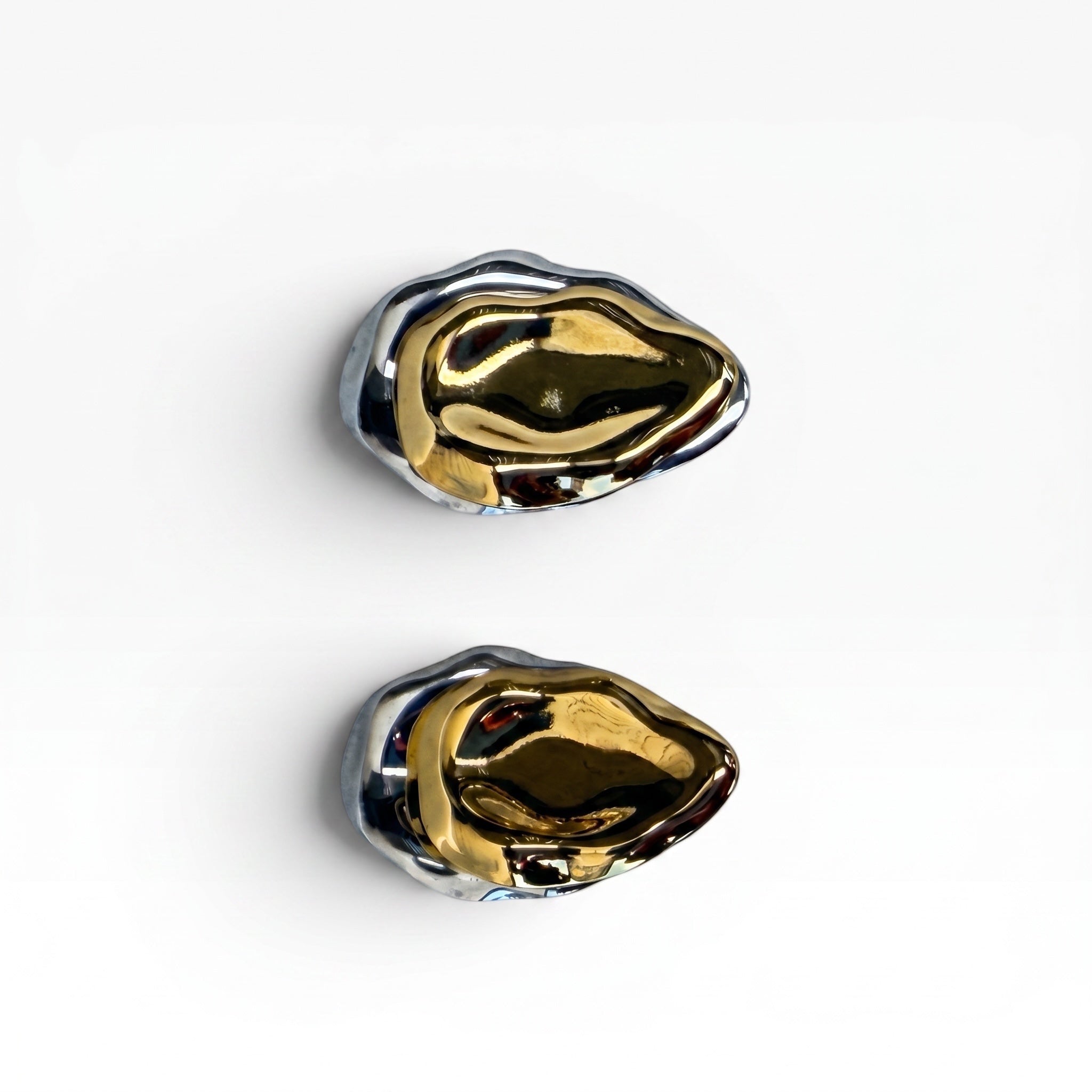 TALI abstract sculptural statement earrings featuring a dual-tone polished gold and silver liquid metal design.