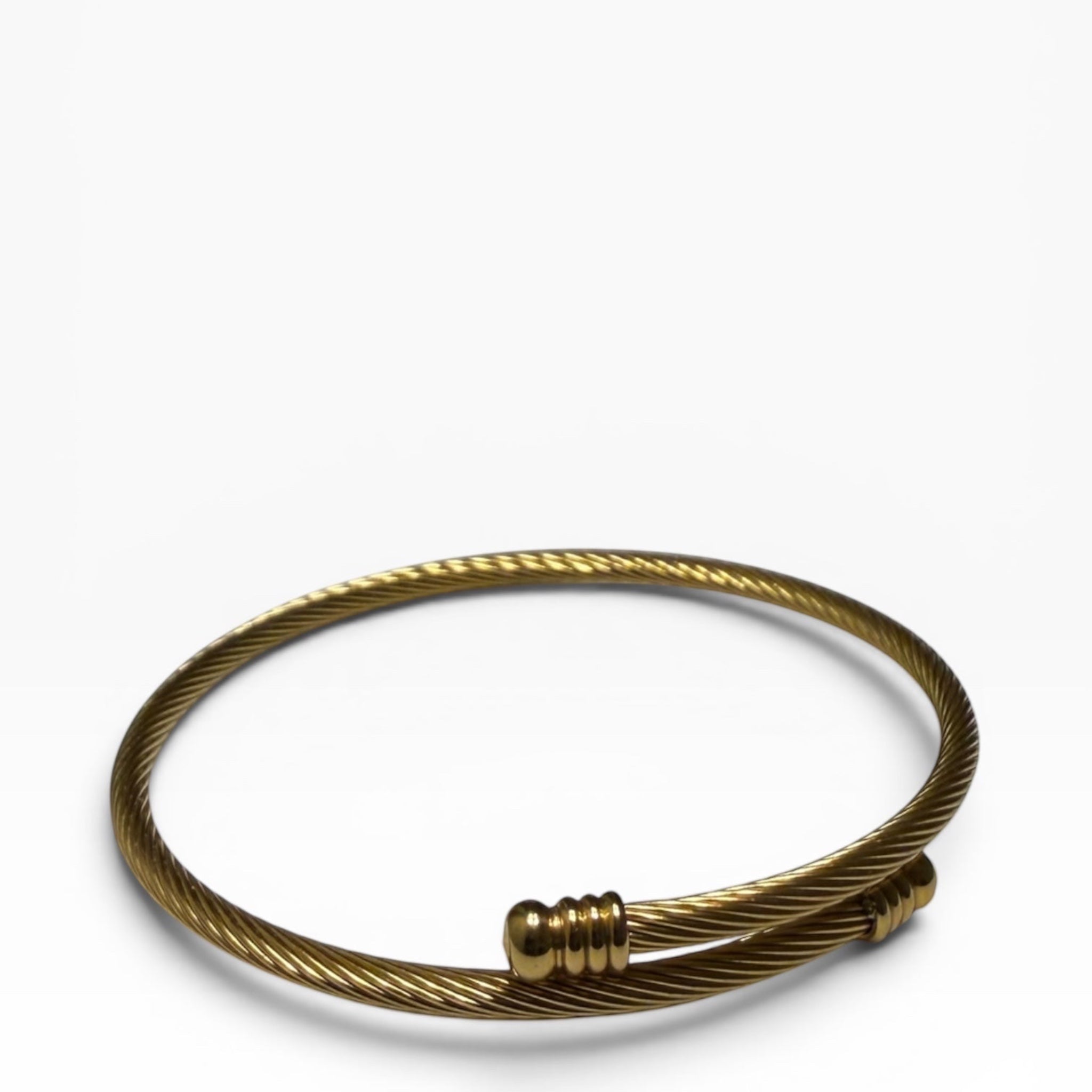 TALI gold-tone twisted wire cable bangle bracelet with polished ribbed end caps in a minimalist open-cuff design.