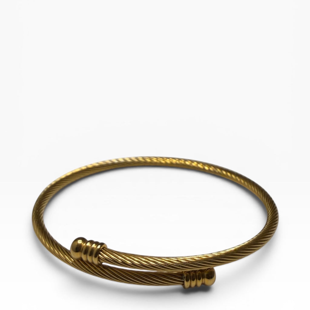 TALI gold-tone twisted wire cable bangle bracelet with polished ribbed end caps in a minimalist open-cuff design.
