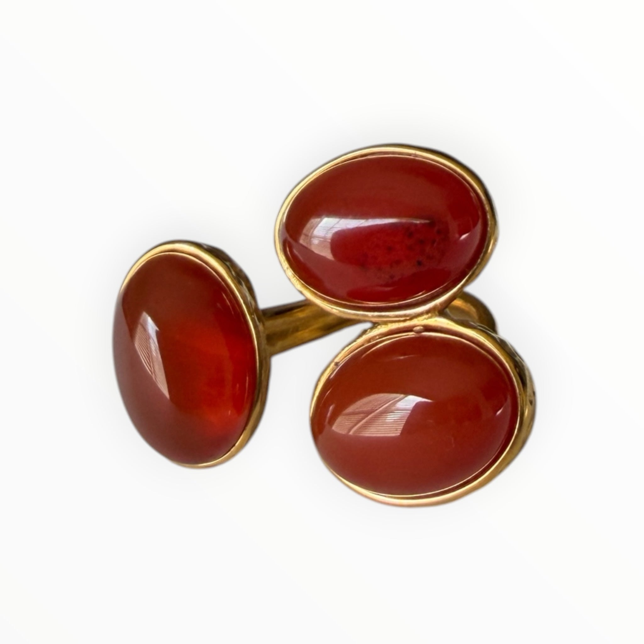 TALI triple oval red cabochon stone statement ring in a gold-toned hammered metal setting.