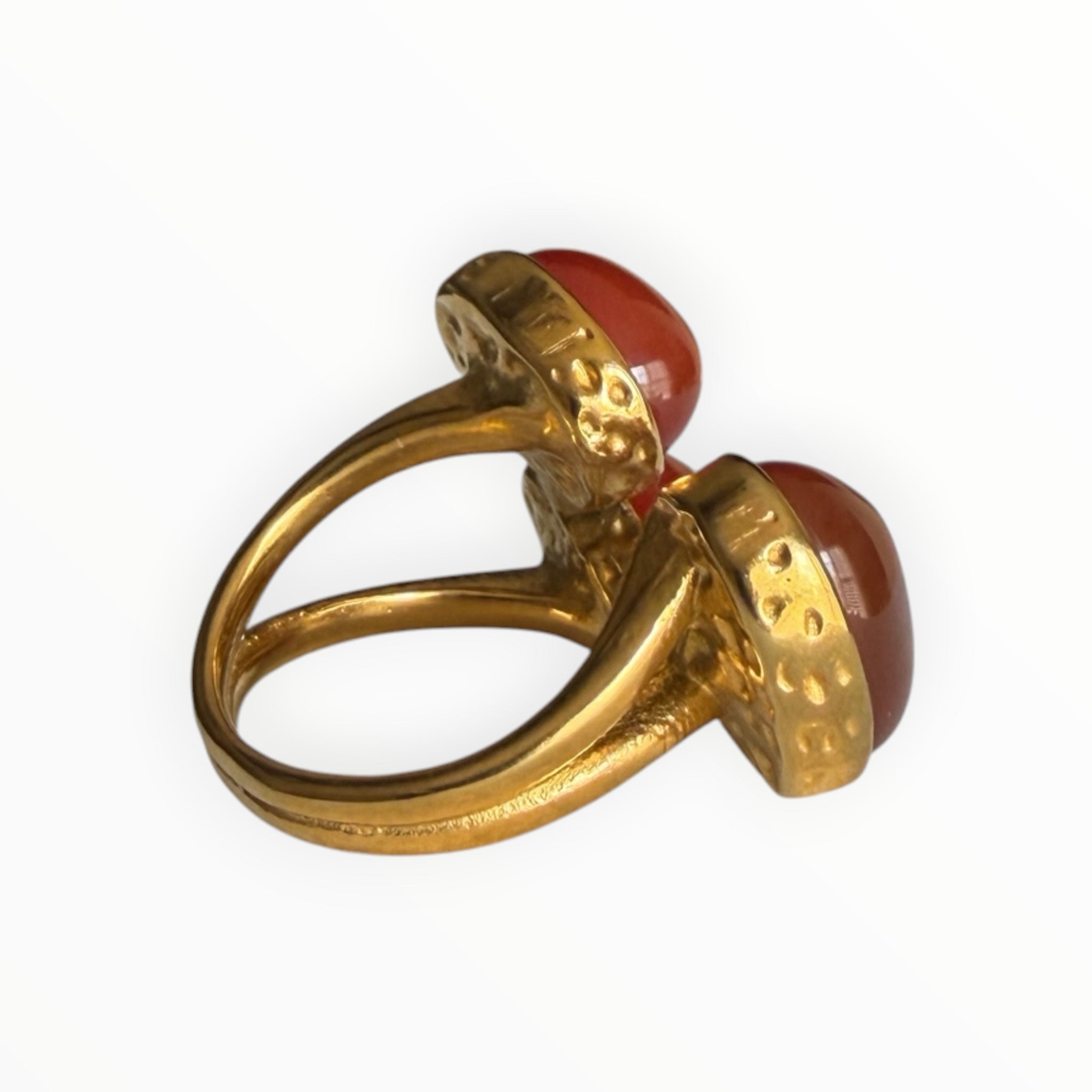 TALI statement ring featuring three oval red cabochon stones in a hammered gold-tone metal setting with a split shank.