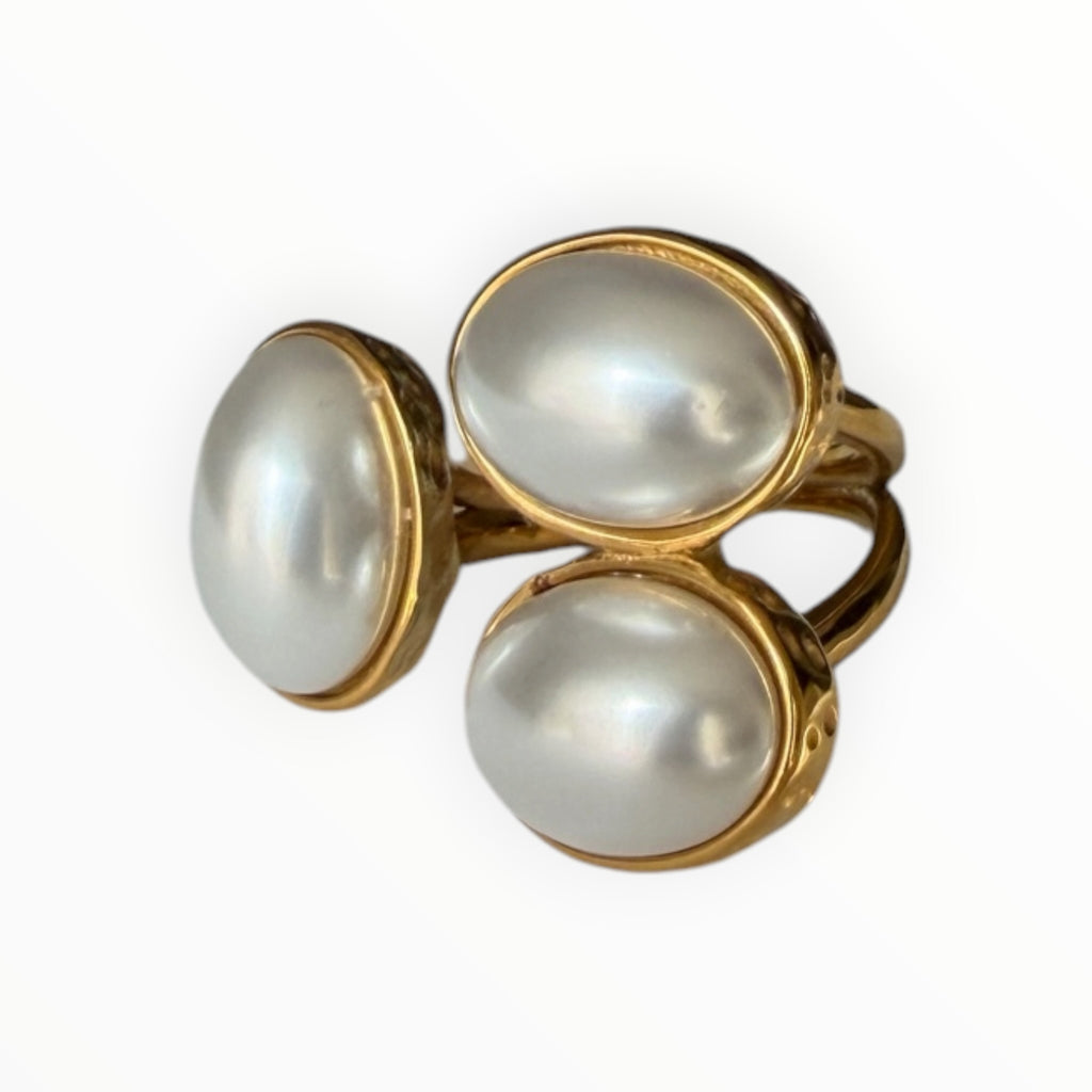 TALI Triple Oval Stone Statement Ring featuring three smooth white cabochon stones in a hammered gold-toned metal setting.