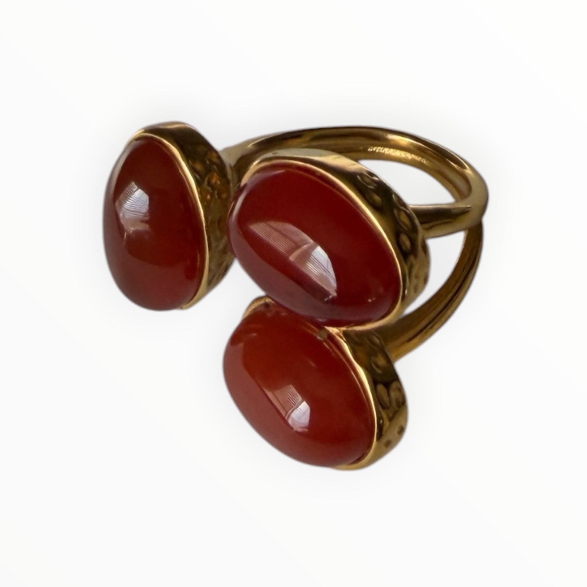 TALI statement ring featuring three smooth red oval cabochon stones in a hammered gold-toned metal setting.